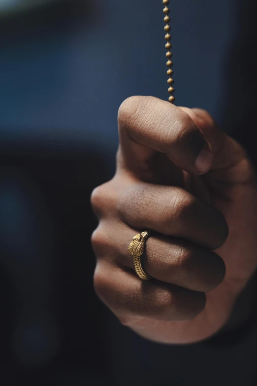 person holding onto a chain with a cross on it