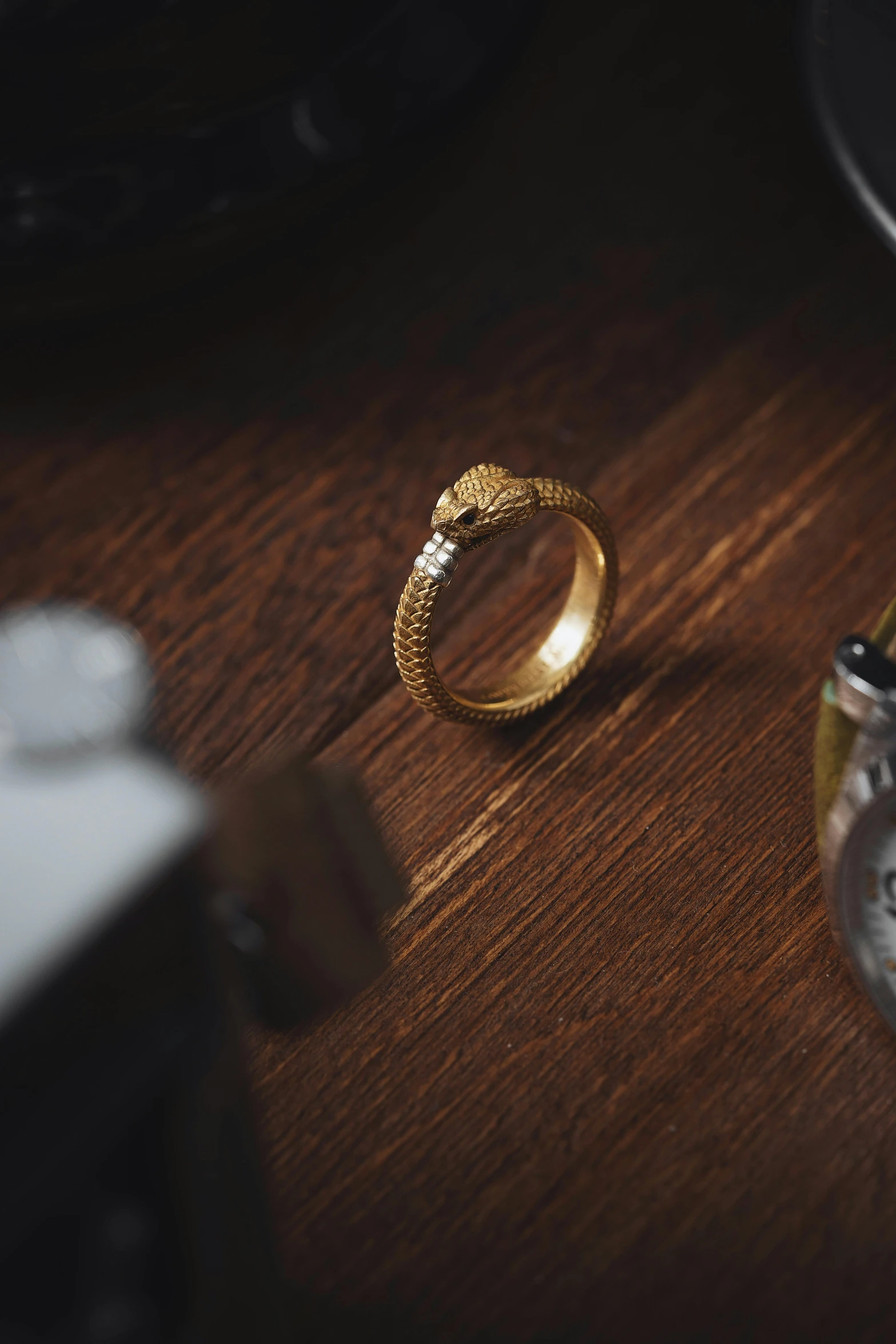 a golden ring sits next to a clock