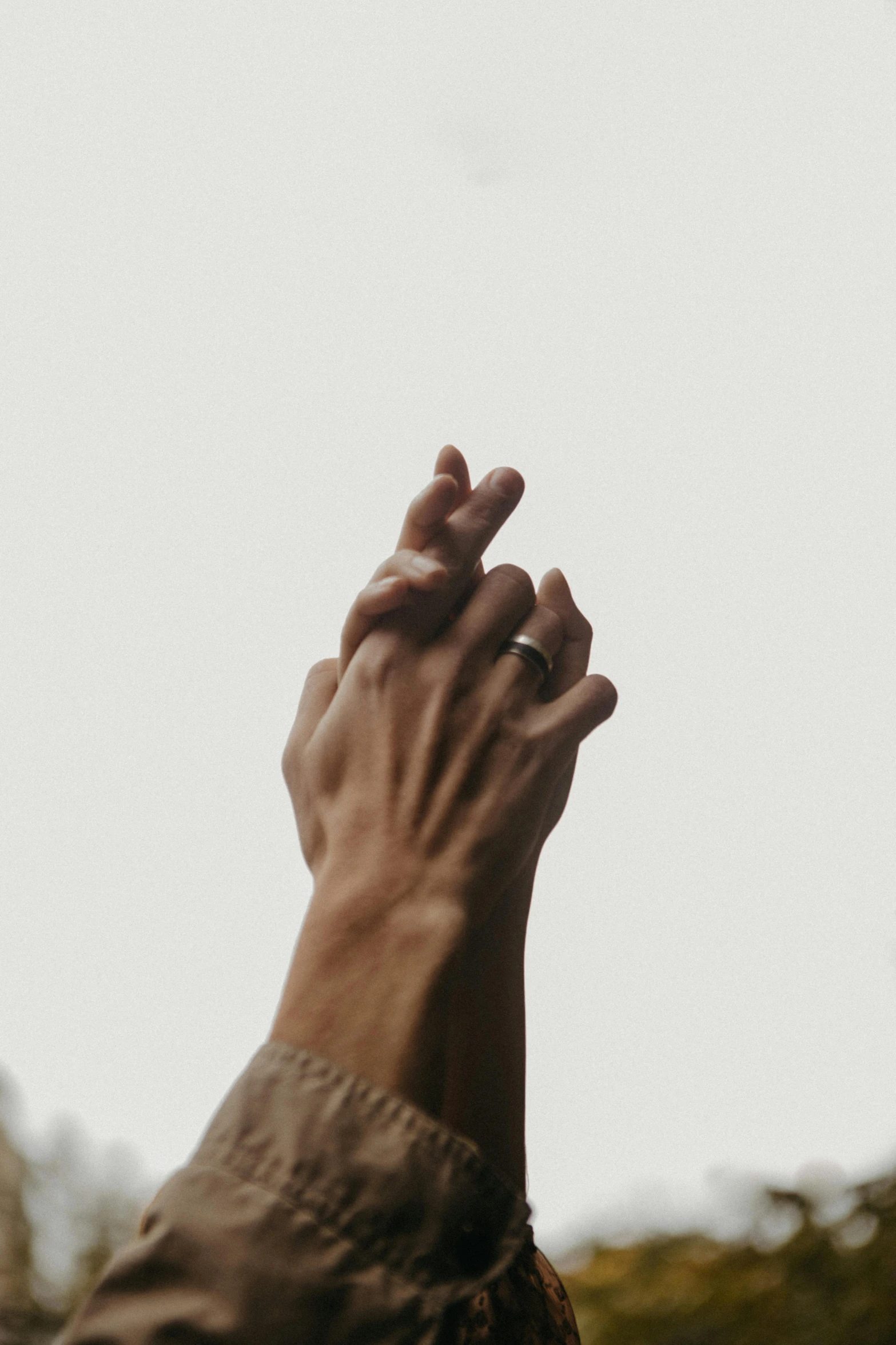 a hand reaching up into the sky to a kite