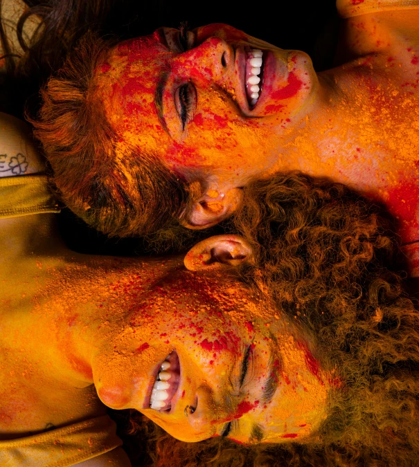 a couple of young men covered in oranges and red