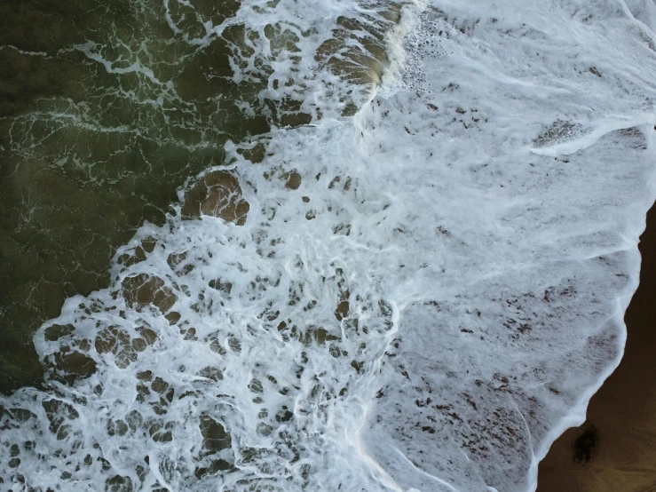 ocean waves on a sandy beach next to the shore