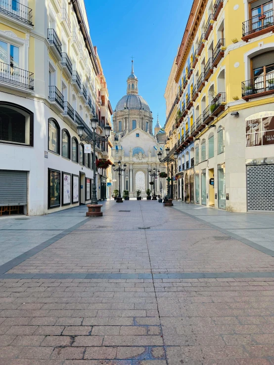 empty sidewalk next to several tall buildings with balconies on each