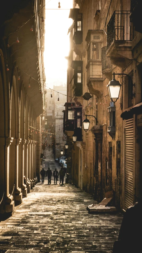 people walking down a small street lined with brick buildings