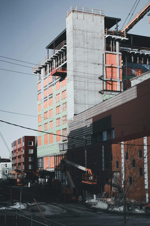 an orange and green building with some buildings under construction