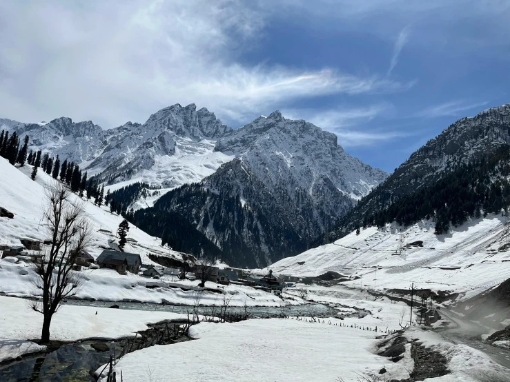 a snow covered mountain range with many mountains and trees