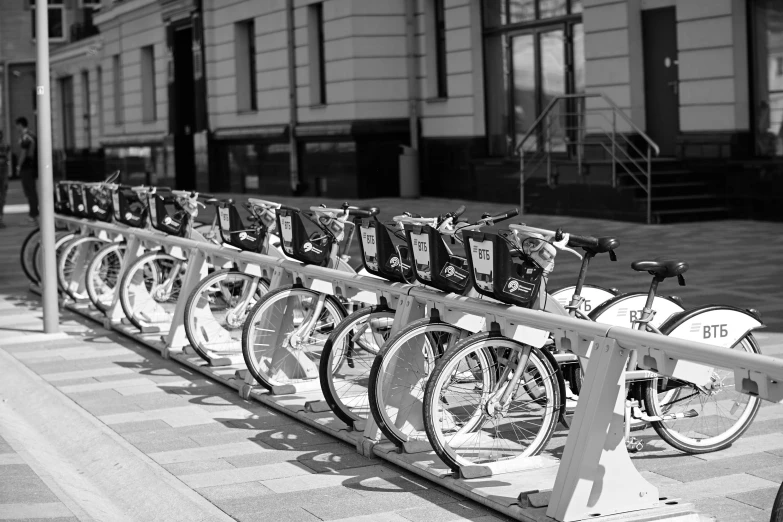 a long line of bikes that are parked on the side of a street