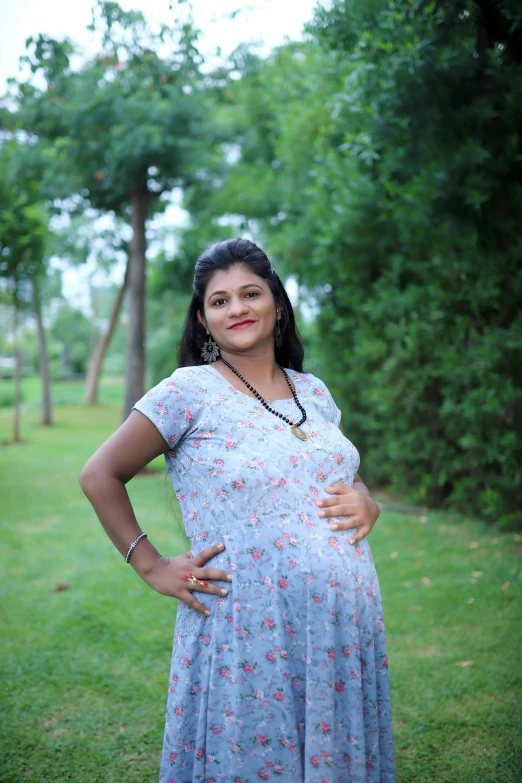 a woman posing in the grass with her hands on her hips