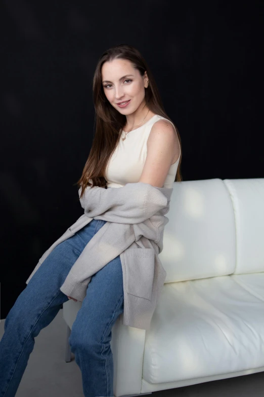 a woman that is sitting on a white couch