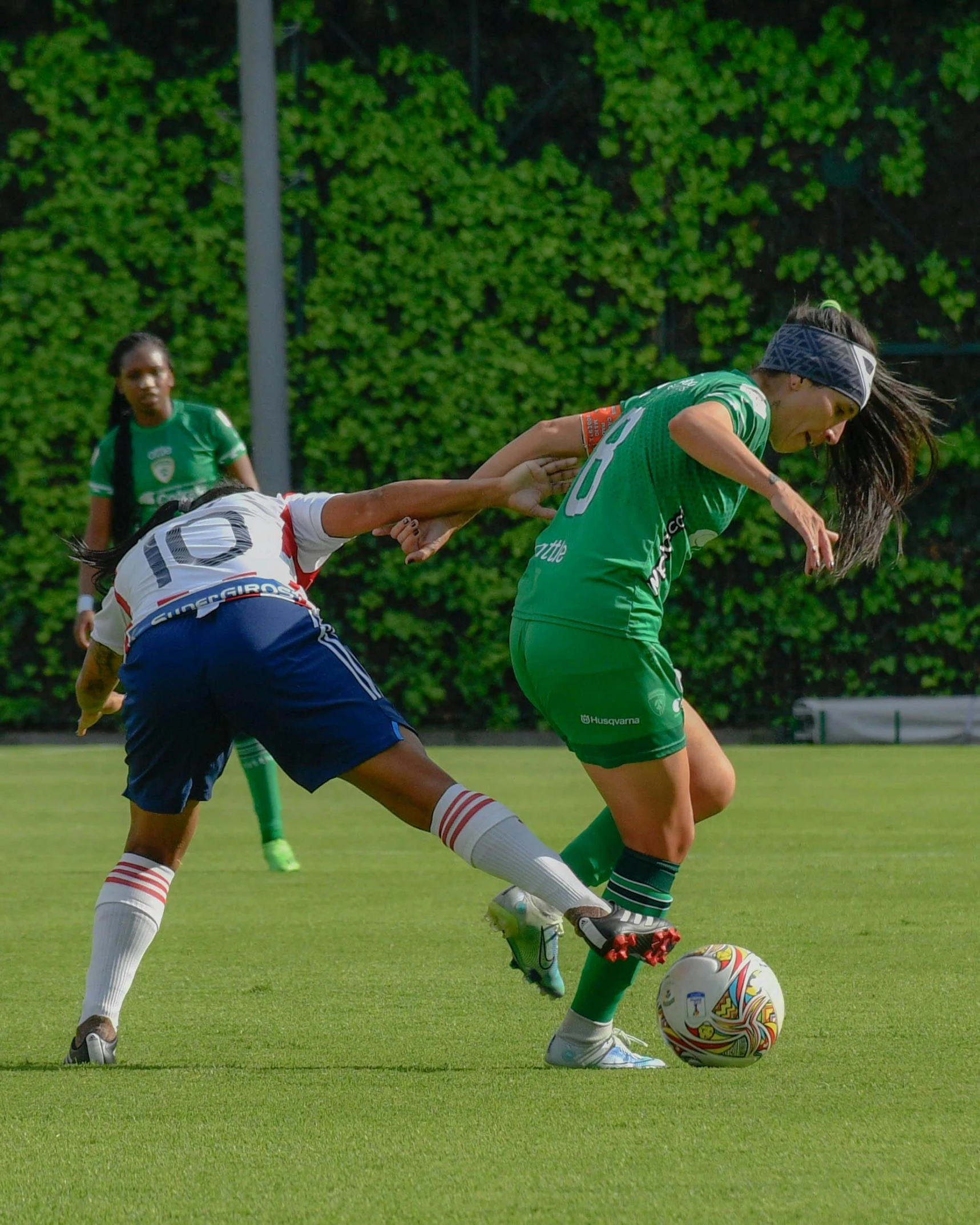 a woman soccer player tries to get past the other team