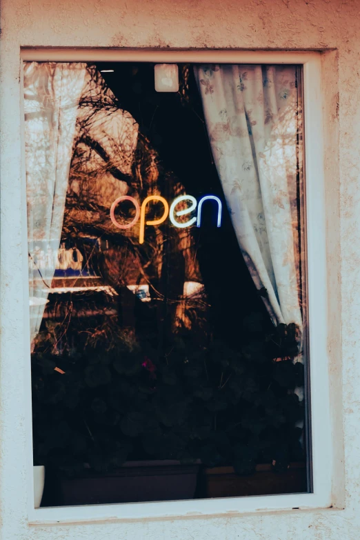 the reflection of the open sign in the window