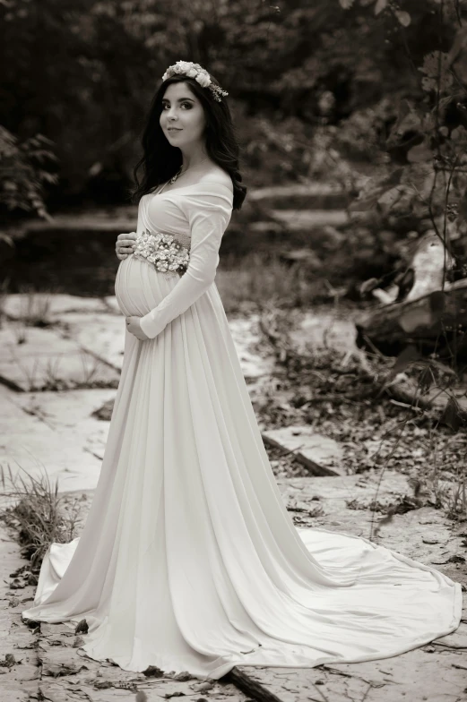 a pregnant woman in a long dress posing