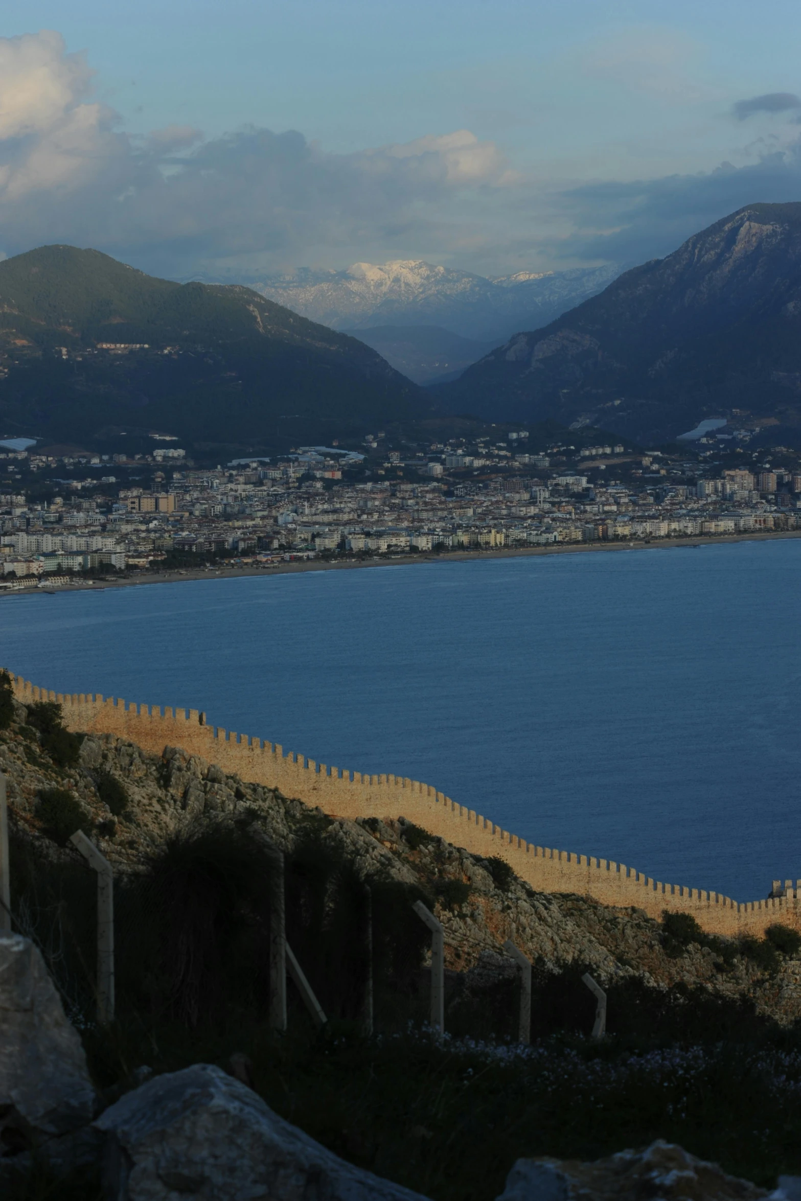 the mountain side with water and a fence