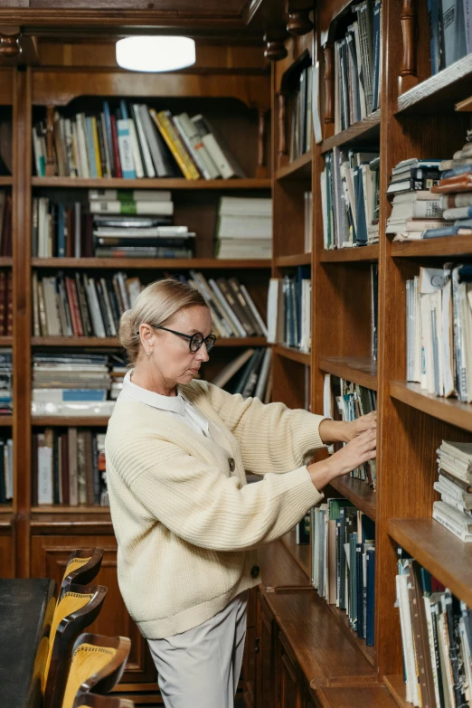 a woman is looking at books in a liry