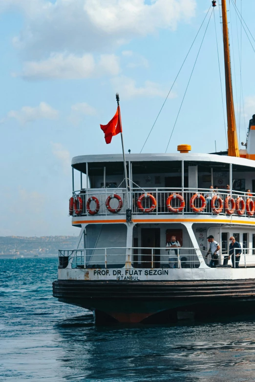 a ship floating on the water with some people near by