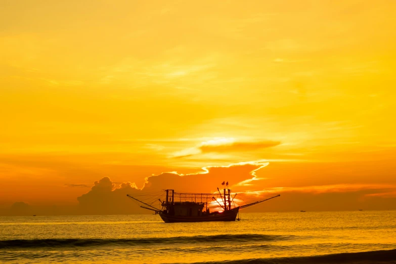 a ship floating on top of the ocean under a cloudy sky