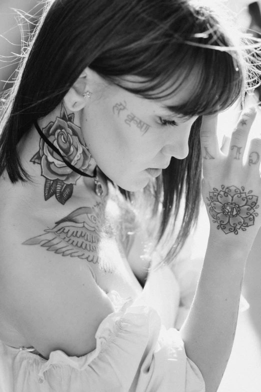 a woman with tattooed arms, hands and a flower on her chest