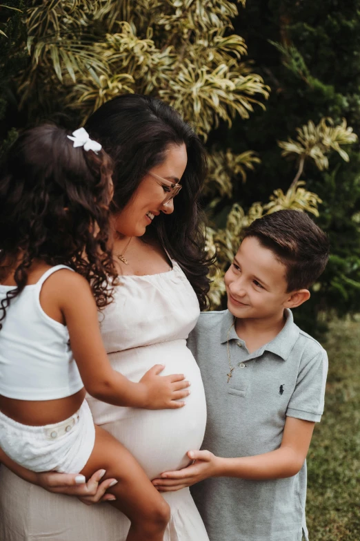 a young woman standing in front of two young children