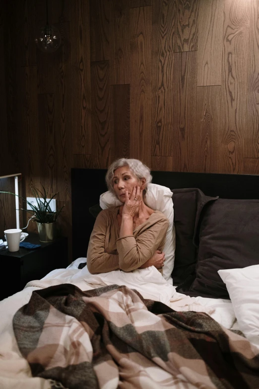 a woman with long hair sits on a bed