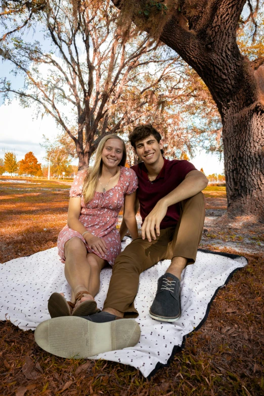 a man and woman are sitting on a blanket together