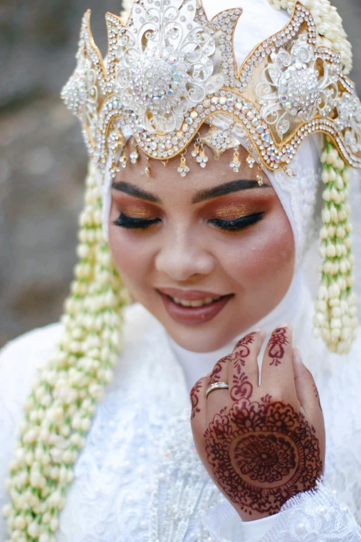 a woman is wearing a white dress and jewelry