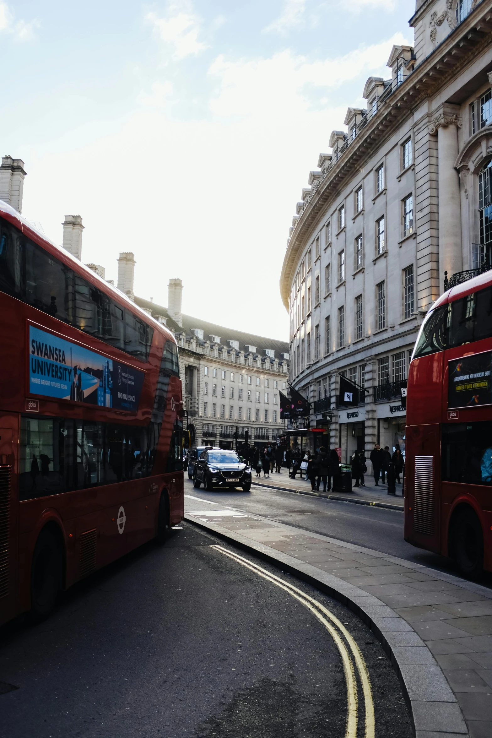 two double decker buses on the road in london