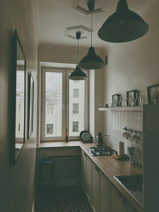 a kitchen is shown with hanging lights and the counters