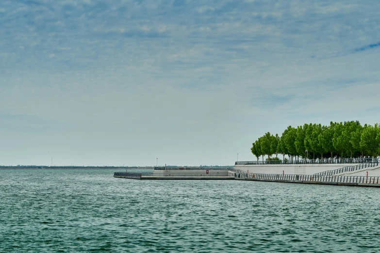 a body of water with small boats and people walking