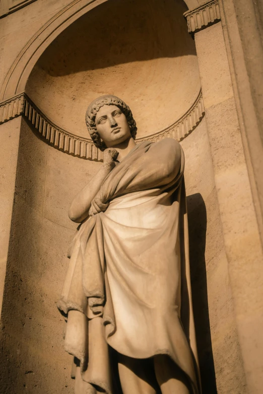 a marble sculpture in the form of a woman in front of an arch