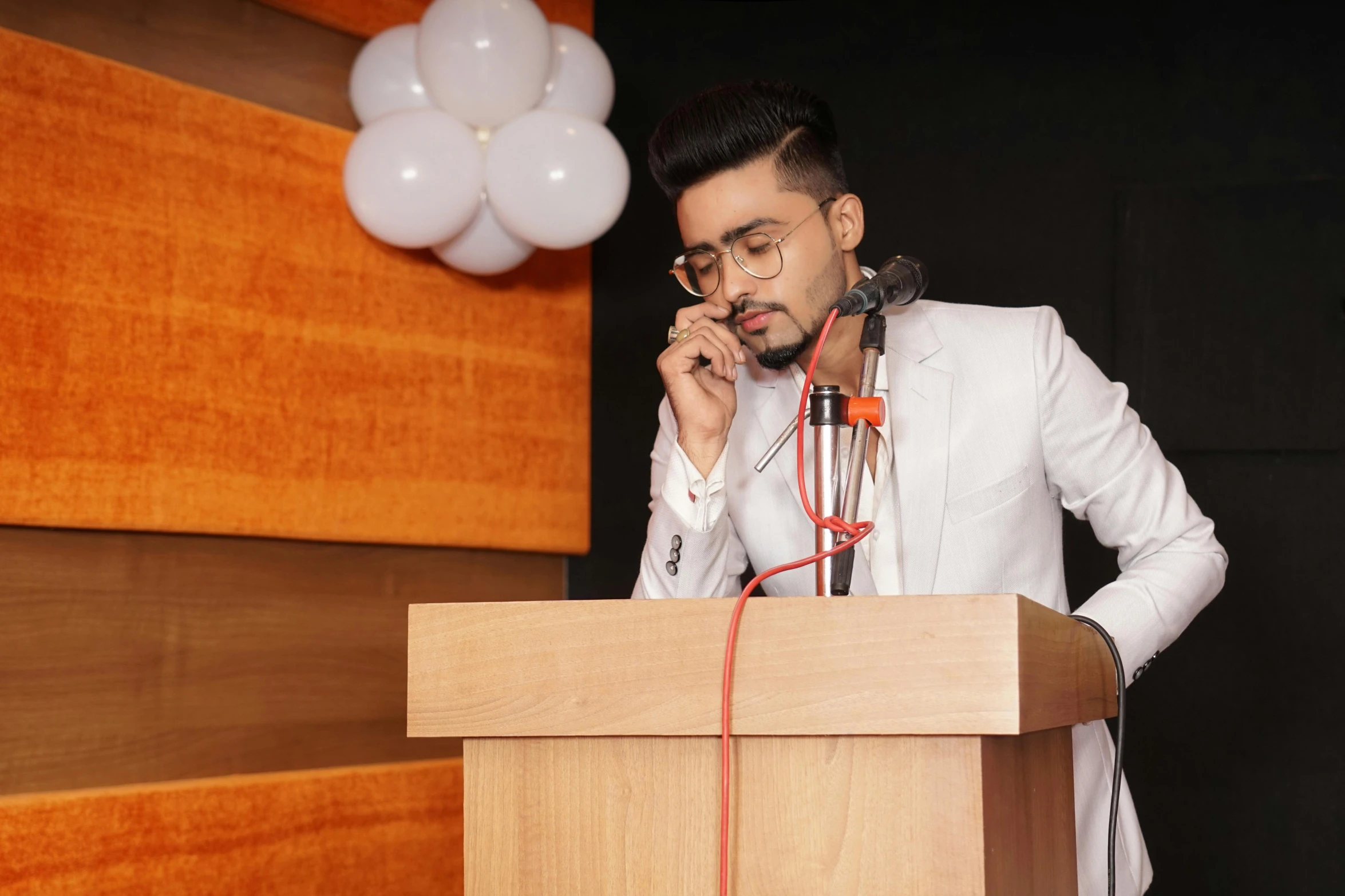 a man stands behind a podium talking on the phone