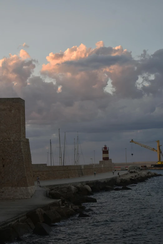 some kind of building with a tower near the ocean