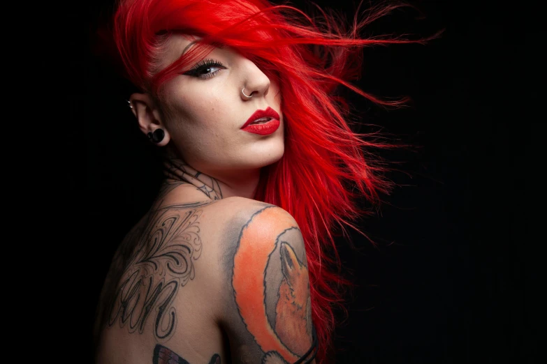 red haired woman with tattoos on her back and chest