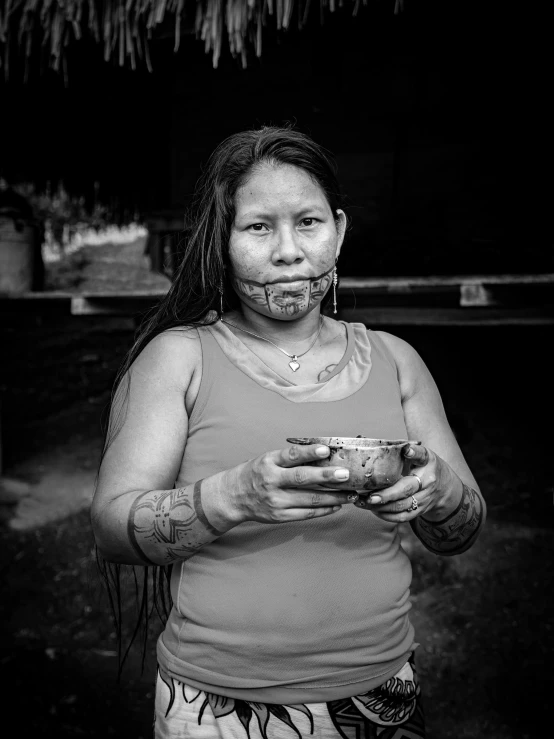 a woman standing with one hand around her face and another holding a bowl