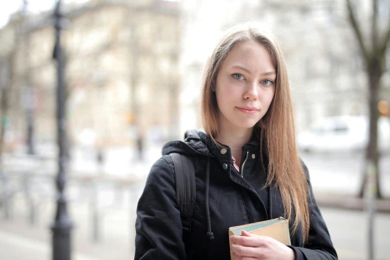 the young woman is holding her hand in her pocket