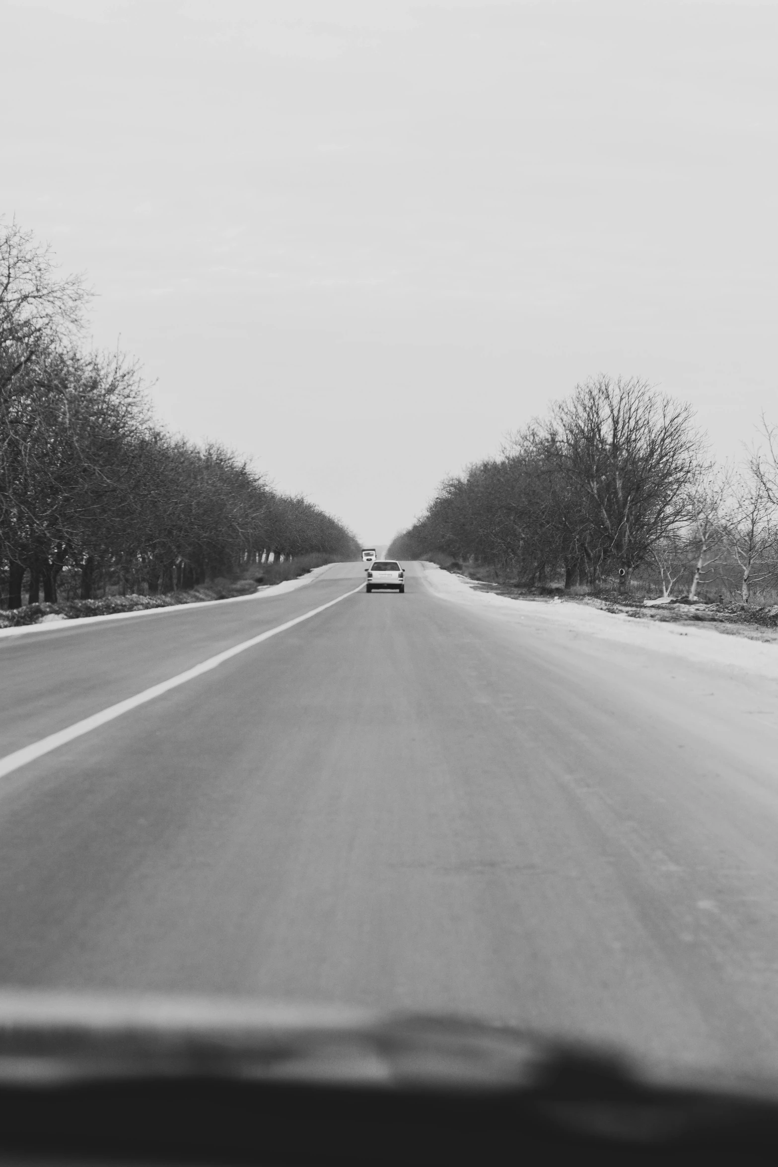 a car driving down the middle of a snowy road