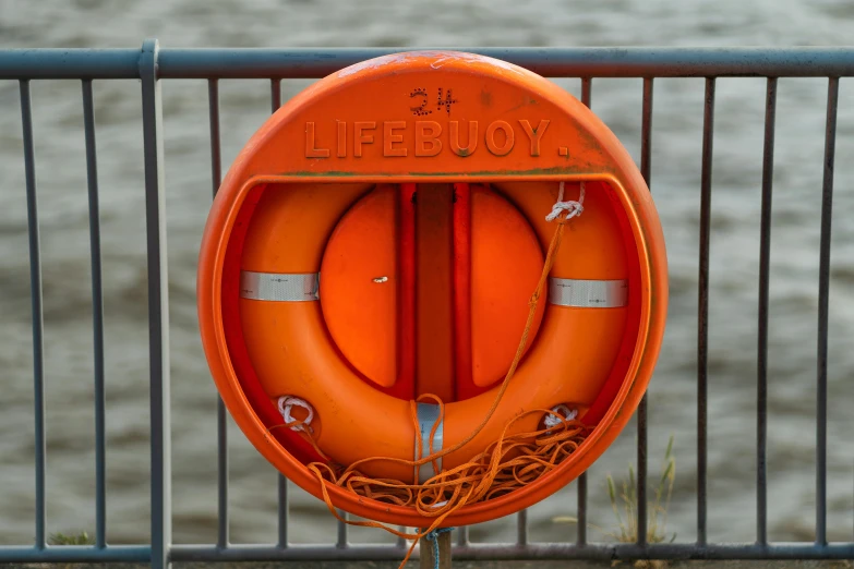 an orange life preserver sits in front of a railing