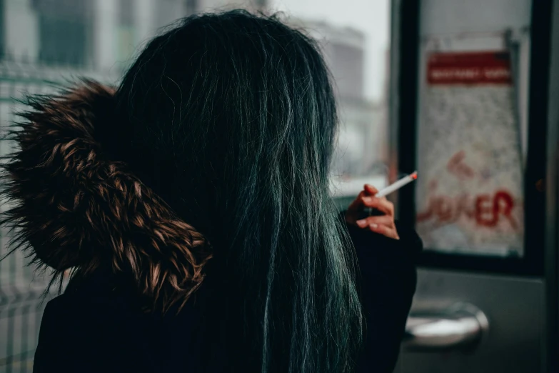 the person with long black hair is smoking