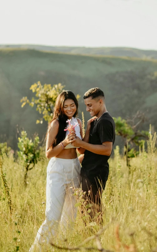 a newly married couple stands together in a field