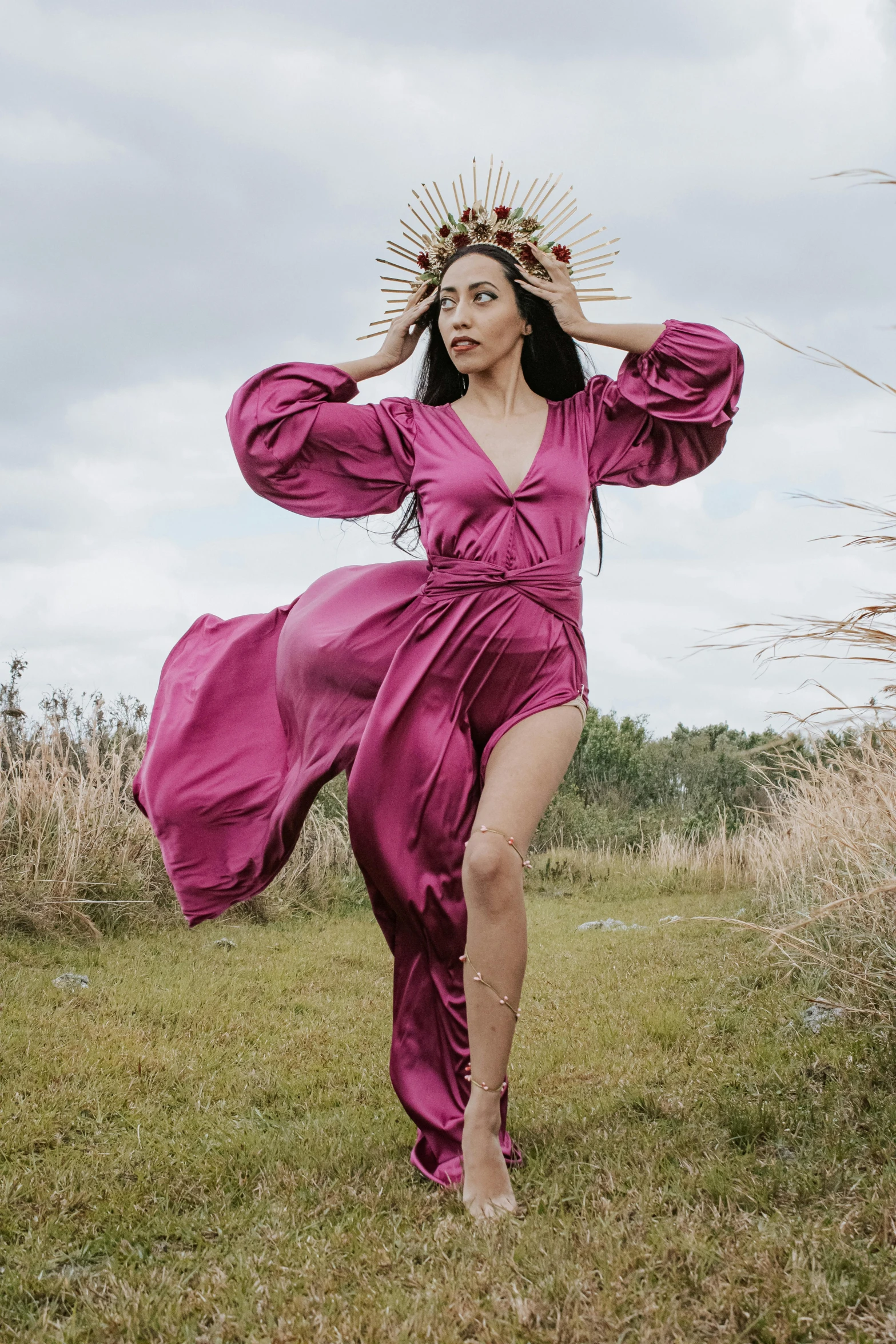 woman in long purple dress walking barefoot with head piece on