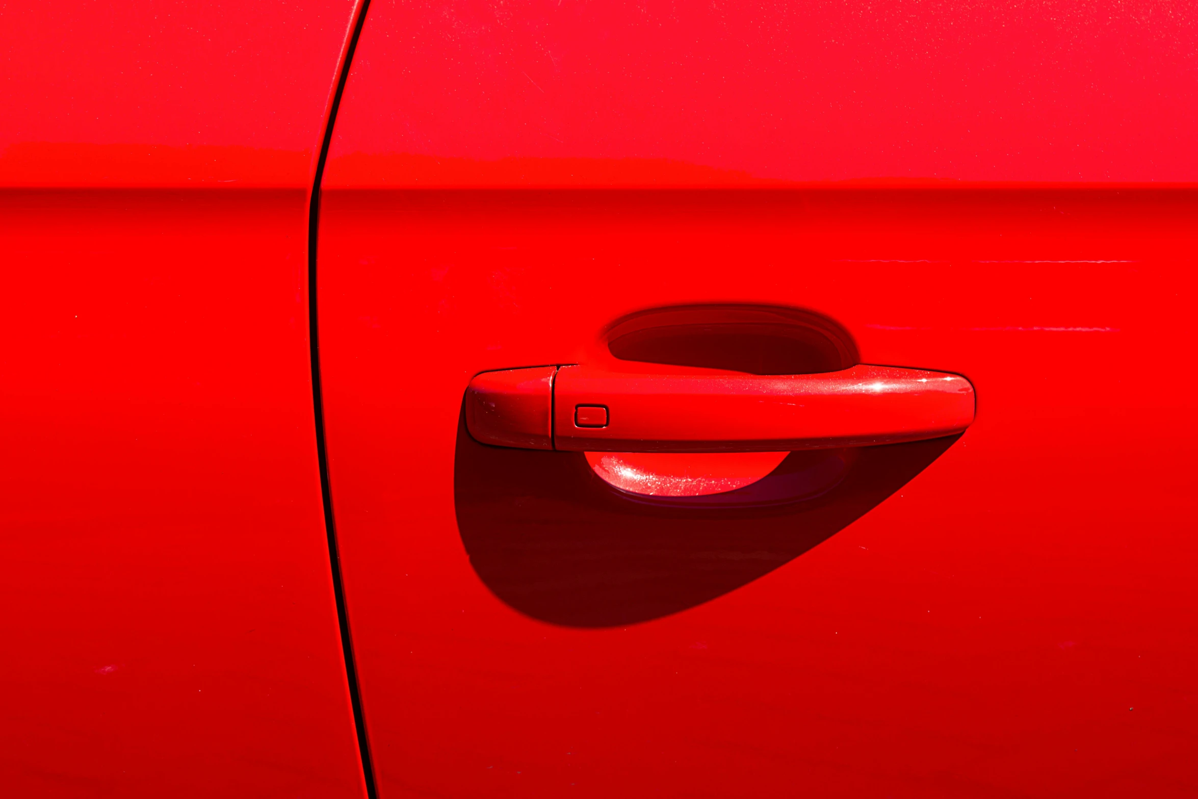 a red vehicle door handle is seen on the front of a red vehicle