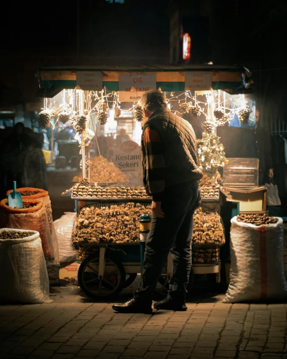 a man standing in front of a store at night