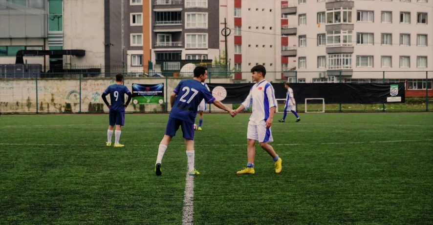 four men shaking hands with the soccer players