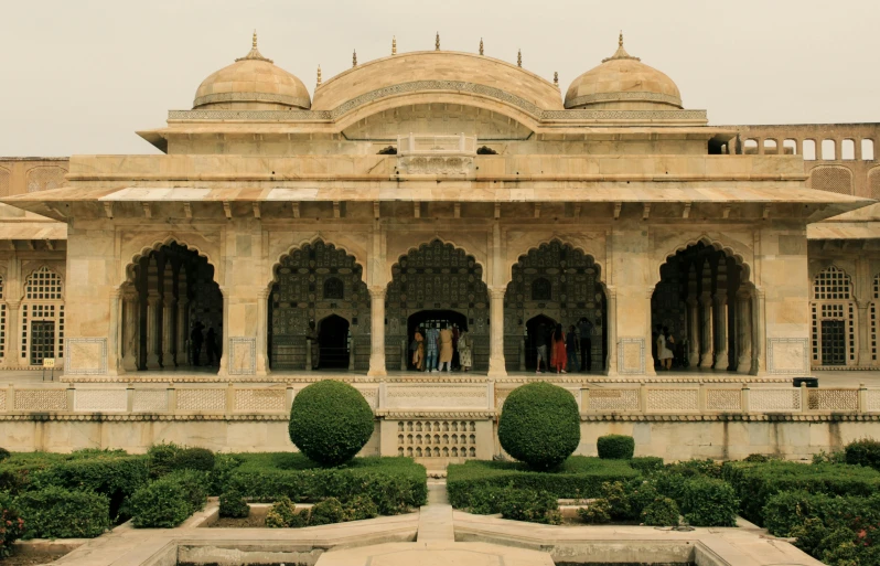 a large building with a green garden in front