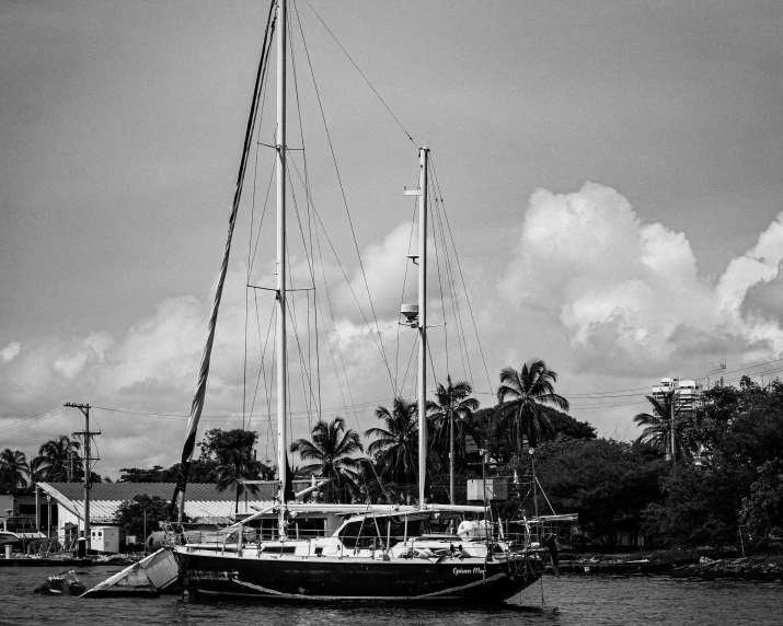 the black and white image of a sailboat in front of a building