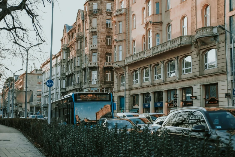 this bus is parked on the side of the road in front of a city building