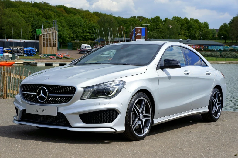 mercedes c class driving next to a lake