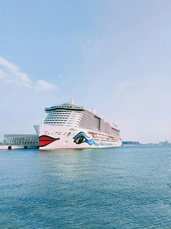 a cruise ship docked in the ocean with people nearby