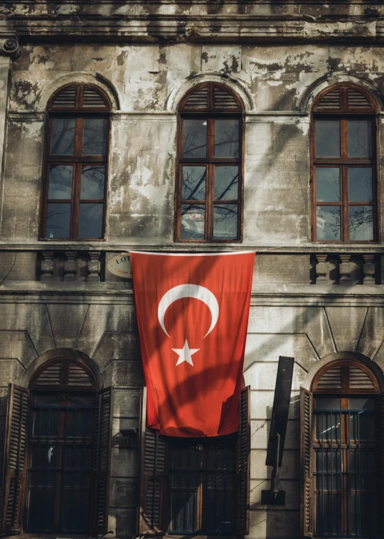 an outside view of a building with a large flag in the foreground