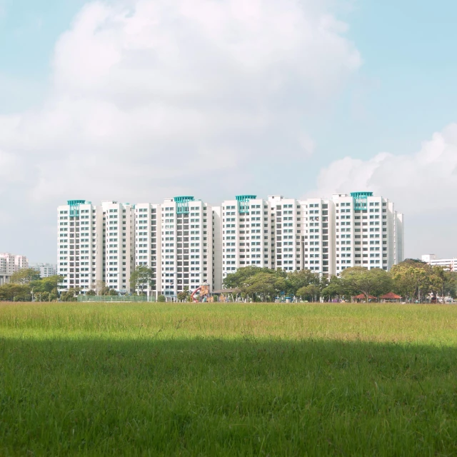 a building that has large windows sits in the middle of a large field