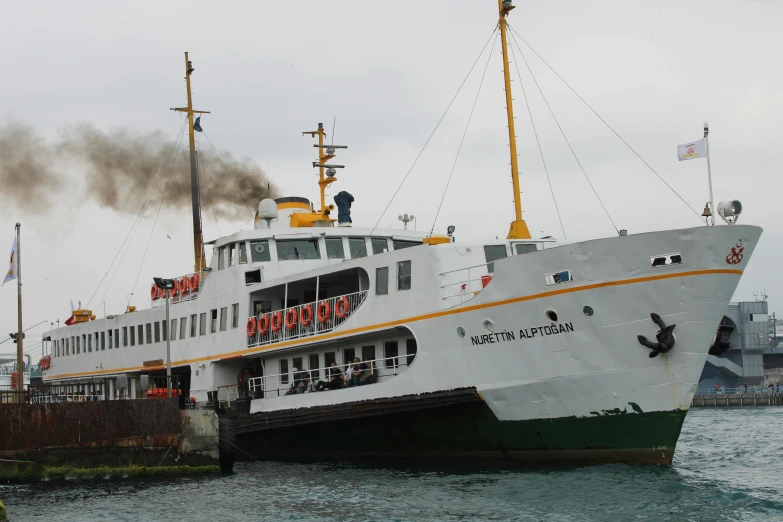 a large boat with several people on top moving along