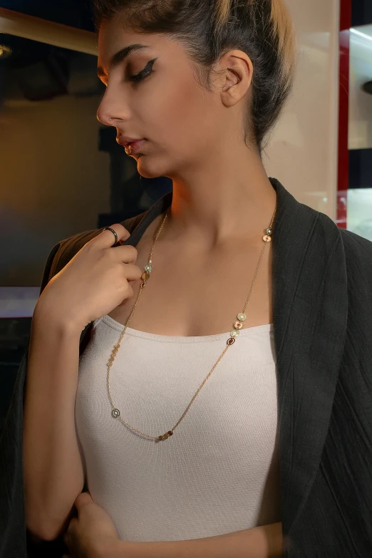 a woman holding a necklace on her neck